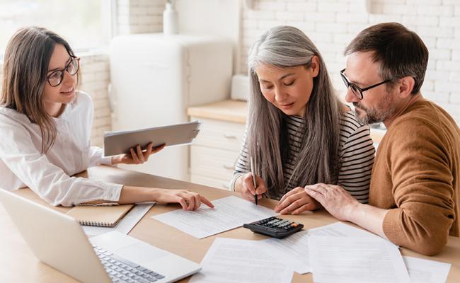 couple meeting with an agent, doing paperwork